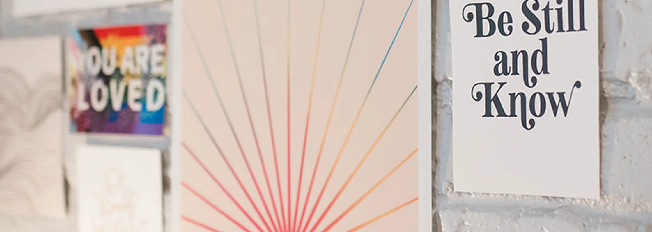 Art prints on the white brick wall of Dr. Lily Zehner's office, including one reading You Are Loved